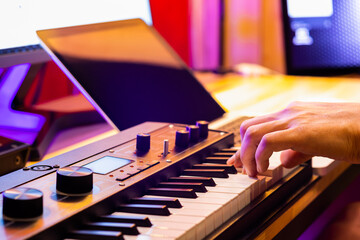 male musician hand playing midi keyboard for arranging music on laptop computer. music production technology concept - 434331833