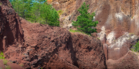visiting the extinct volcano we climb the reddish rocks covered with green vegetation
