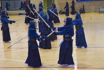 Group of people practising Kendo, a traditional japanese self defense martial art. With samurai...