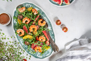 salad with shrimps, arugula, tomatoes and citrus fruits