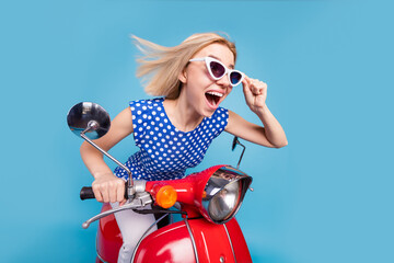 Fototapeta na wymiar Profile side photo of young excited girl happy positive smile ride bike speed hand touch sunglass isolated over blue color background