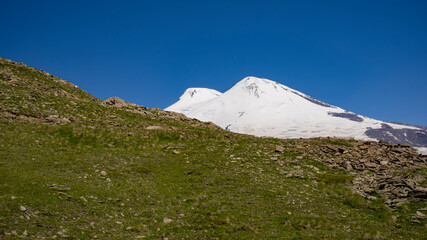 View from the slope of Mount Cheget to the two peaks of the Elbrus volcano while ascending the cable car. July 2020.Kabardino-Balkaria, Russia.