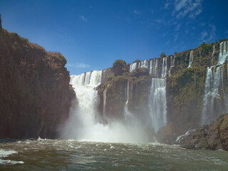 Great Iguasu waterfalls seen from the boat behind fog and falling water splashes