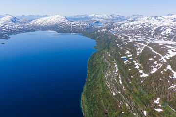 Lake and snow covered mountain scenery from above