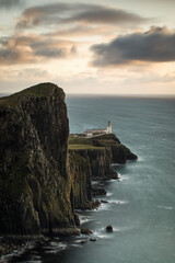 Neist Point and the lighthouse on Isle of Skye at sunset with beautiful colourful clouds in background - Scotland, UK.