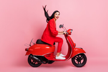 Fototapeta na wymiar Full size profile side photo of young crazy excited smiling girl riding moped fast extreme isolated on pink color background