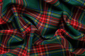 Texture of crumpled green and red tartan fabric close up. background for your mockup. traditional Scottish clothing