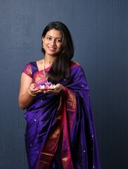 Indian Girl or women holding Pooja Thali offering applying tika