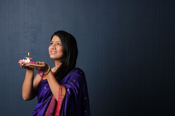 Indian Girl or women holding Pooja Thali offering applying tika