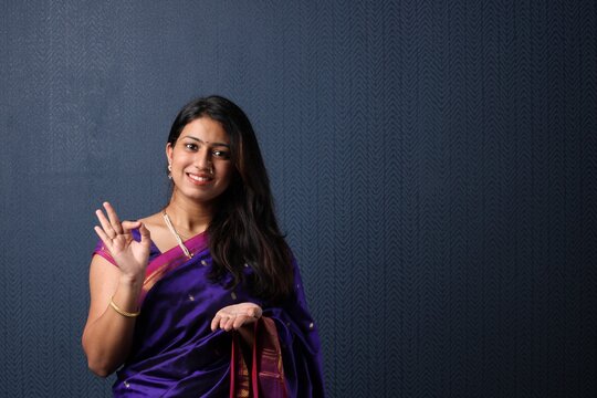 Smiling Attractive Indian Woman in saree Showing Copyspace or presenting