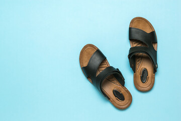 Men's leather sandals on a light blue background. Flat lay.