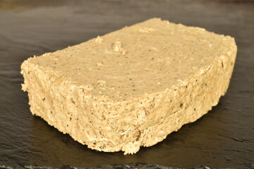 One slice of vanilla halva, on a slate serving board, close-up.