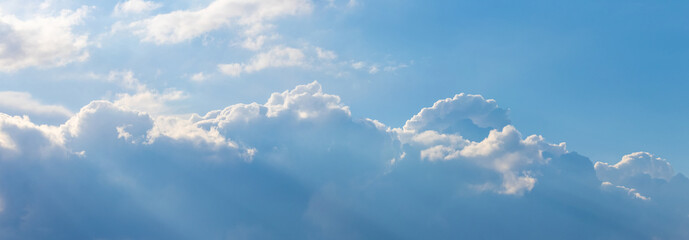 Blue and white clouds in the sky in bright sunlight