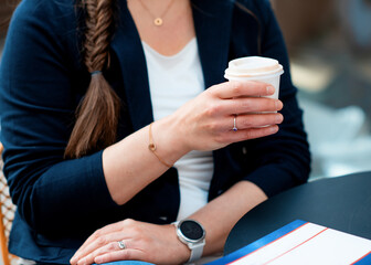 woman holding cup of coffee and waiting for somebody