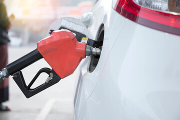 Closeup of woman pumping gasoline fuel in car at gas station. Petrol or gasoline being pumped into...