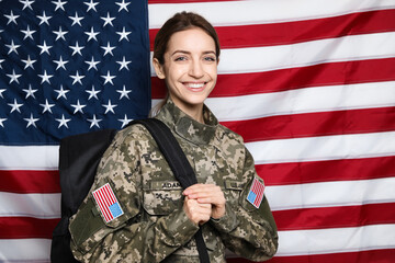 Female cadet with backpack against American flag. Military education