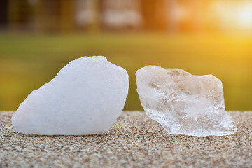 Closeup view of alum cubes on stone marble floor with sunlight in the sunset background.