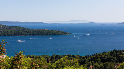 Fototapeta na wymiar View of the sea bay near Trogir in Croatia from a mountain road. Many yachts move on the sea