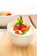 Yogurt with strawberry on the top in white plates