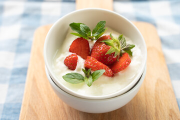 Close-up of yogurt with strawberry on the top in white plates