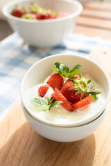 Yogurt with strawberry on the top in white plates
