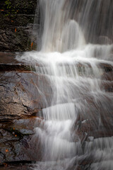 Fototapeta na wymiar Water creates dramatic patterns as it falls over rocks