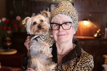 Posh senior woman with vintage leopard print look matching her dog