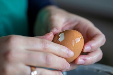A close up portrait of the hands of a person peeling the shell of a hard boiled egg, making it ready to eat for breakfast, lunch or maybe dinner in a cold dish.