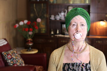 Moody senior woman using a pacifier