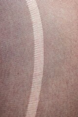 A closeup macro portrait of the texture of a rip, tear, run, ladder in the fabric of black nylon stockings, pantyhose. The pattern of the threads is wider apart at the rip.