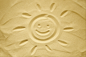 Fototapeta na wymiar face of smiling sun drawn in sand, summer beach holidays