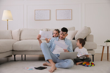 Overwhelmed man combining parenting and work at home