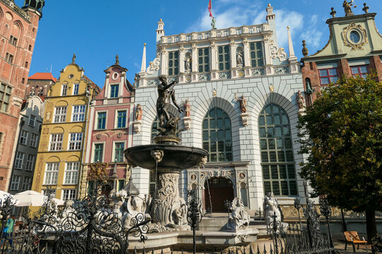 The Neptune's Fountain in Old Town of Gdansk, Poland. The fountain is located in the central point. Town Hall building in the back. City tour. Clear and bright day.