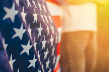 National flag of America close up, selective focus, standing in a field at sunset. 4th of July,...
