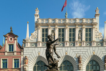 The Neptune's Fountain in Old Town of Gdansk, Poland. The fountain is located in the central point. Town Hall building in the back. City tour. Clear and bright day. © Chris