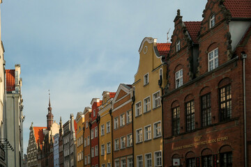Fototapeta premium A close up of the facades of tall building in the middle of Old Town in Gdansk, Poland. The buildings have many bright colors, they are richly decorated. City tour. Clear day.