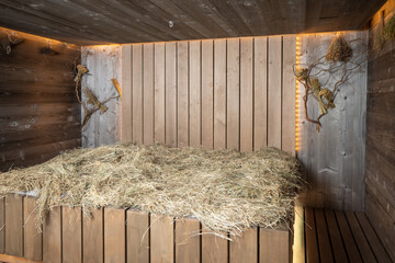 Interior of a wooden sauna, steam room, bathhouse with hay on wooden bench. 