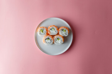 sushi roll Philadelphia on a plate on a pink background. Delicious fresh roll with curd cheese,...