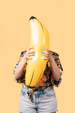 unknown woman with summer clothes holding an inflatable banana