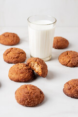 Freshly Homemade baked ginger cookies with cinnamon, sugar and glass of milk on light marble background. 
