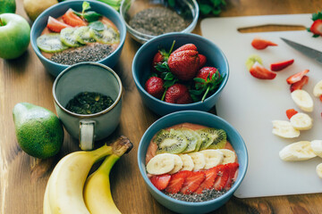 On the table are bowls of ready-made fruit smoothies, decorated with fruits. Cooking.