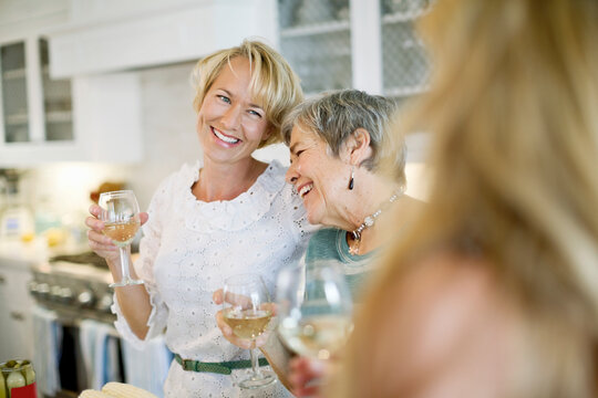 Happy mother and daughter holding wineglasses