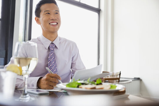 Businessman Working On Documents While Dining Out