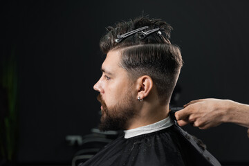 Low fade machine haircut for handsome bearded man in barbershop. Hair cut with a smooth transition. - obrazy, fototapety, plakaty