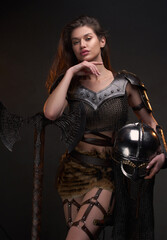 Fototapeta premium Young woman viking posing with helmet and axe