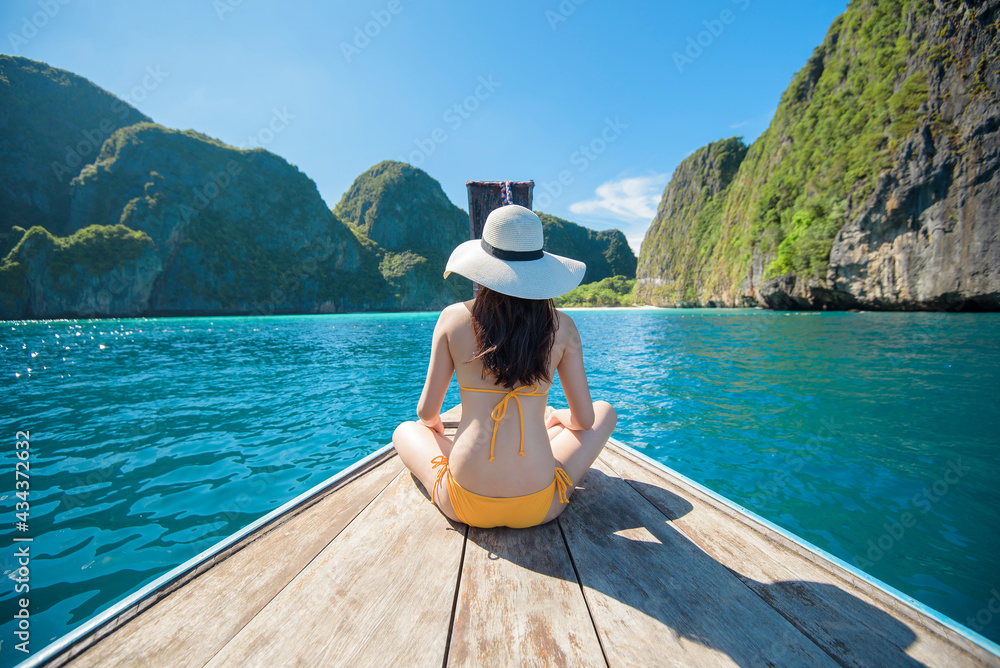 Wall mural view of woman in swimsuit enjoying on thai traditional longtail boat over beautiful mountain and oce