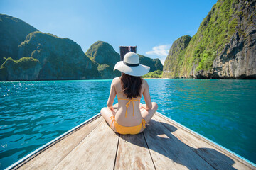 View of woman in swimsuit enjoying on thai traditional longtail Boat over beautiful mountain and...
