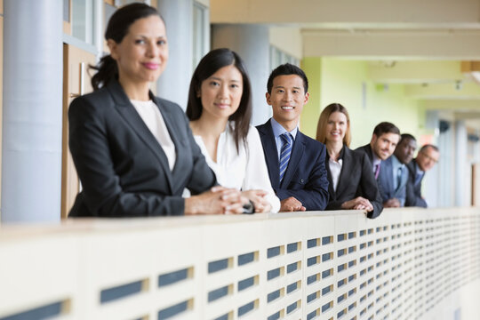 Portrait Of Confident Business Team Standing By Railing