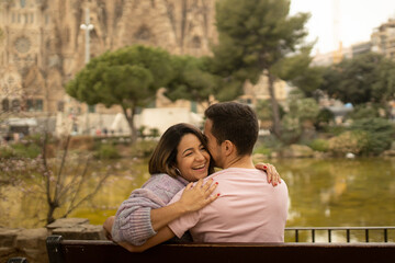 Naklejka premium A couple in a romantic moment smiling and hugging in a park