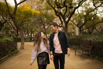 A happy couple walking and smiling looking each other 